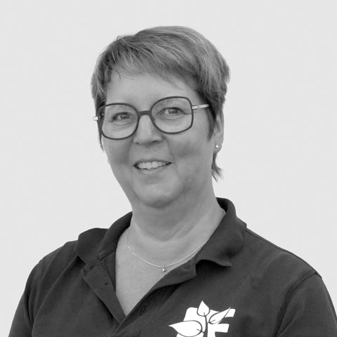 Dronninglund Efterskole lærer i klassisk skoleuniform, smilende, med fokus på elevengagement.