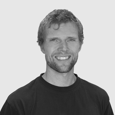 Smilende mand på Dronninglund Efterskole med elever og skolemiljø, fokus på læring og fællesskab.