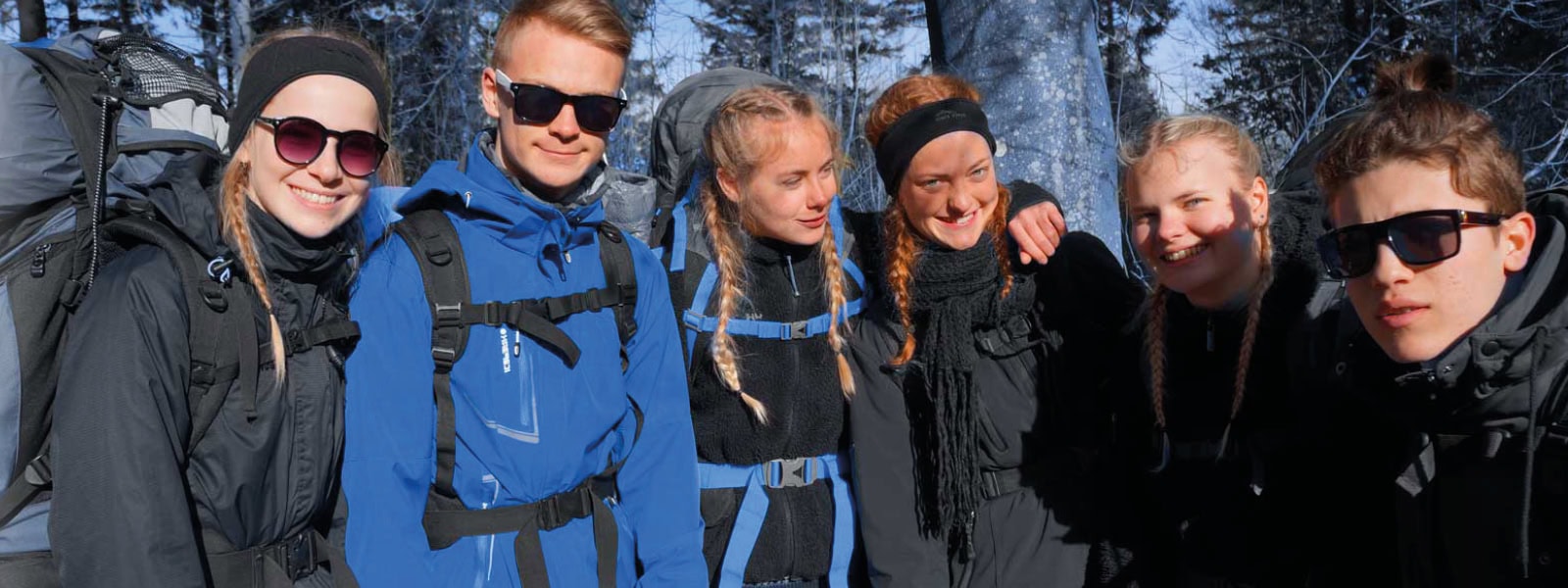 Unge elever på Dronninglund Efterskole nyder udendørs eventyr i sneen.